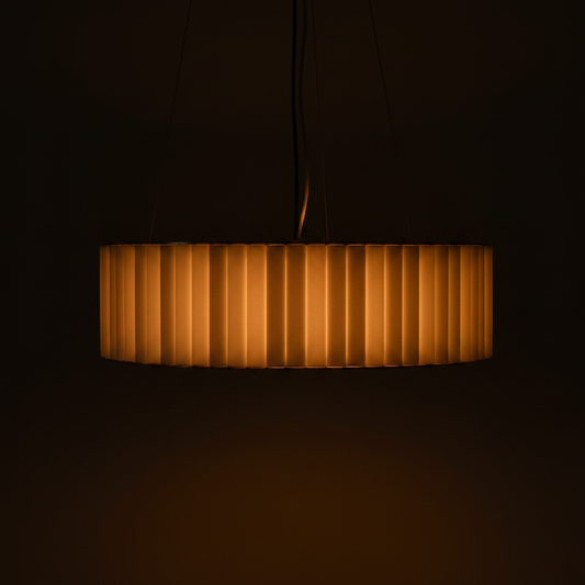 Aura Fluted Drum Pendant Light – Warm 2700K glow through ribbed glass on dark charcoal background