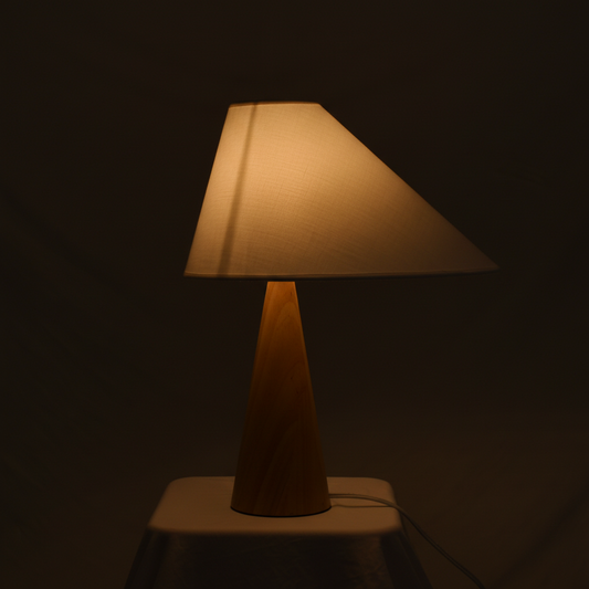 Asymmetric Drift Table Lamp – Warm 2700K glow through linen shade on dark charcoal background